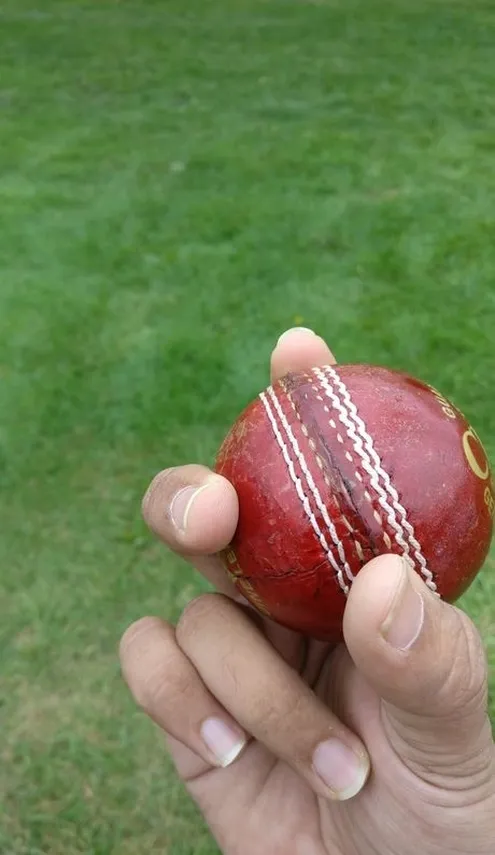 Passo 1 Agarre a bola com o seu dedo indicador na costura e coloque o seu dedo médio no lado direito da costura.