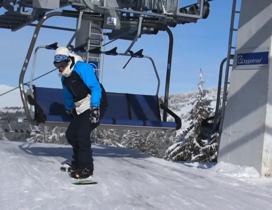 Como entrar em um teleférico de esqui com uma prancha de snowboard