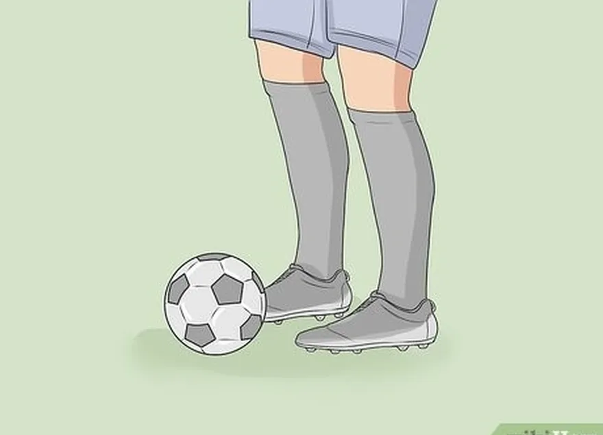 Passo 2 Colocar uma bola de futebol ao lado do pé de remate ou ligeiramente atrás dele.