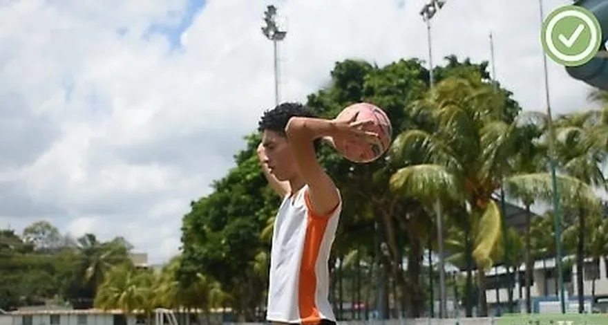 passo 1 pegue a bola com as duas mãos, uma de cada lado da bola.