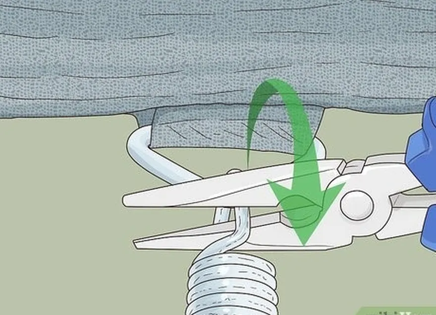 Etapa 2 Desencaixe a primeira mola do trampolim com um alicate de cabeça chata.
